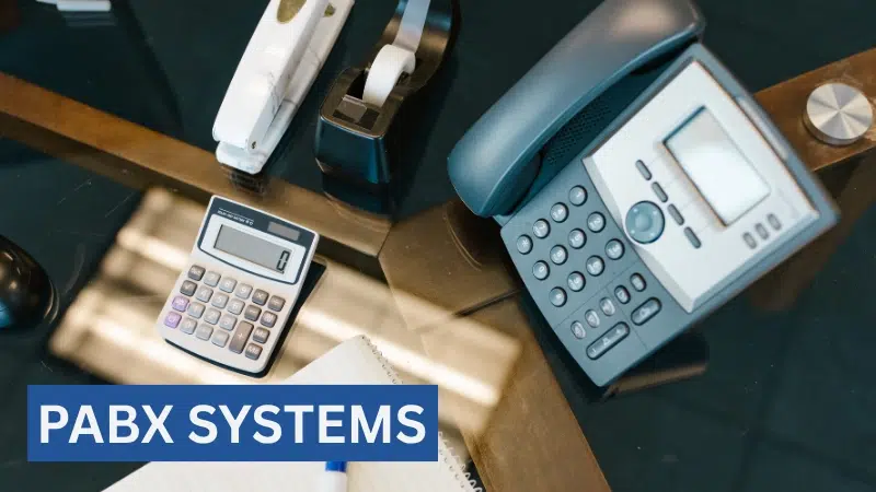Office desk with telephone and calculator representing modern PABX systems for business communication.