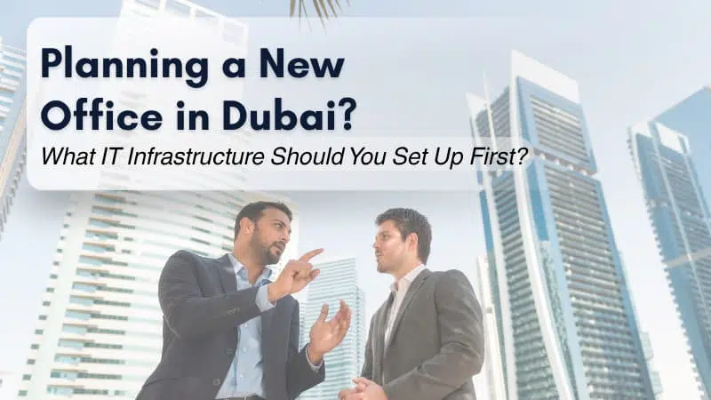 Two business professionals discussing IT infrastructure setup in front of modern office buildings in Dubai.